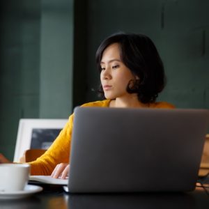 young business woman in yellow dress sitting at table in cafe and writing in notebook student t20 9lPGJN